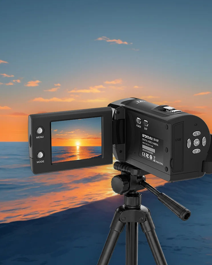 Black ORDRO DV-107 vlogging camera mounted on a tripod capturing an ocean sunset to demonstrate the time-lapse shooting feature